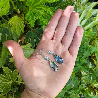 silver drop earrings in hand for scale