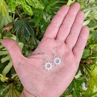 sun dangle earrings in hand for scale