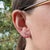 gold star constellation earrings in ear