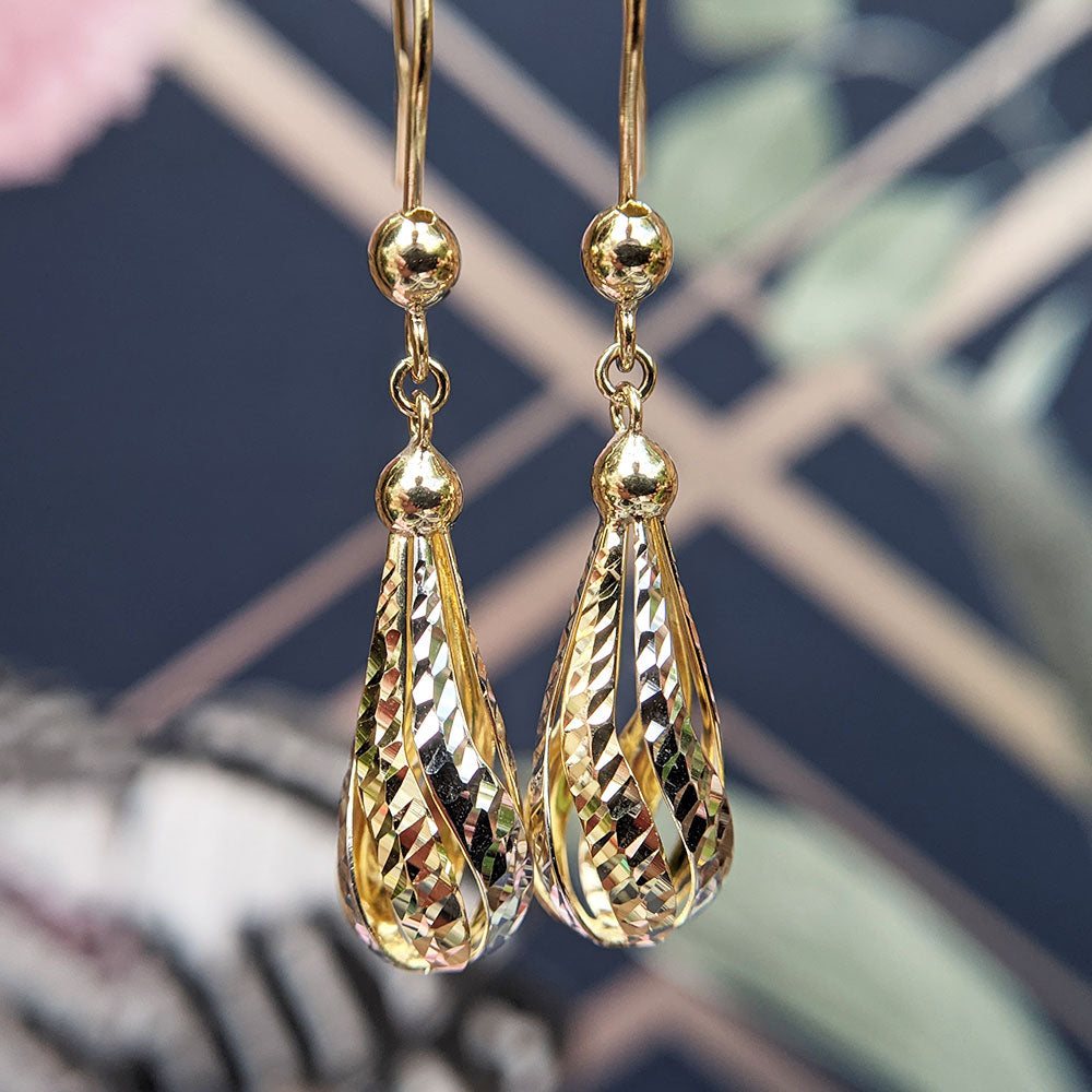close up of women's gold drop earrings