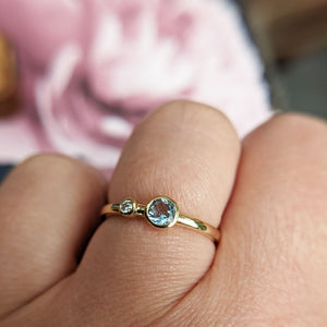 aquamarine and diamond ring on finger