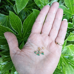 emerald earrings in hand for scale