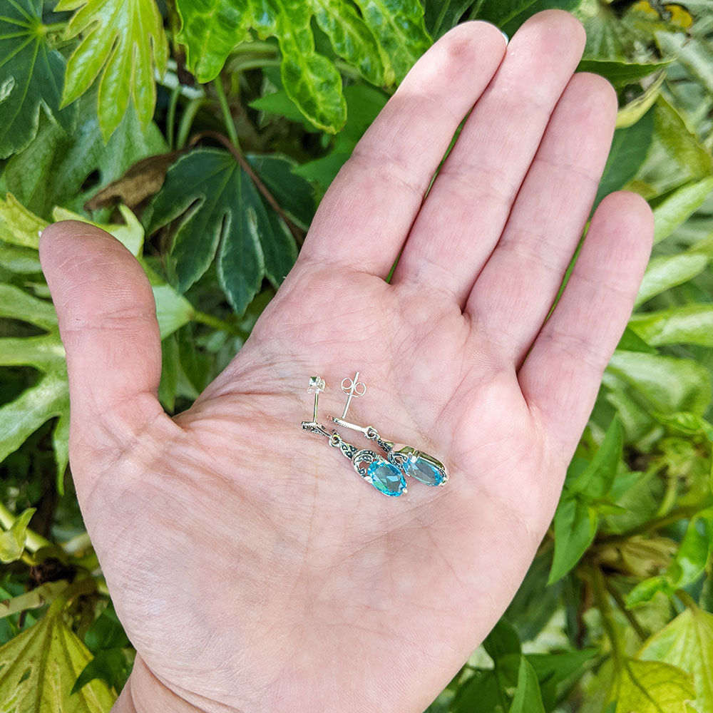 blue paste earrings in hand for scale