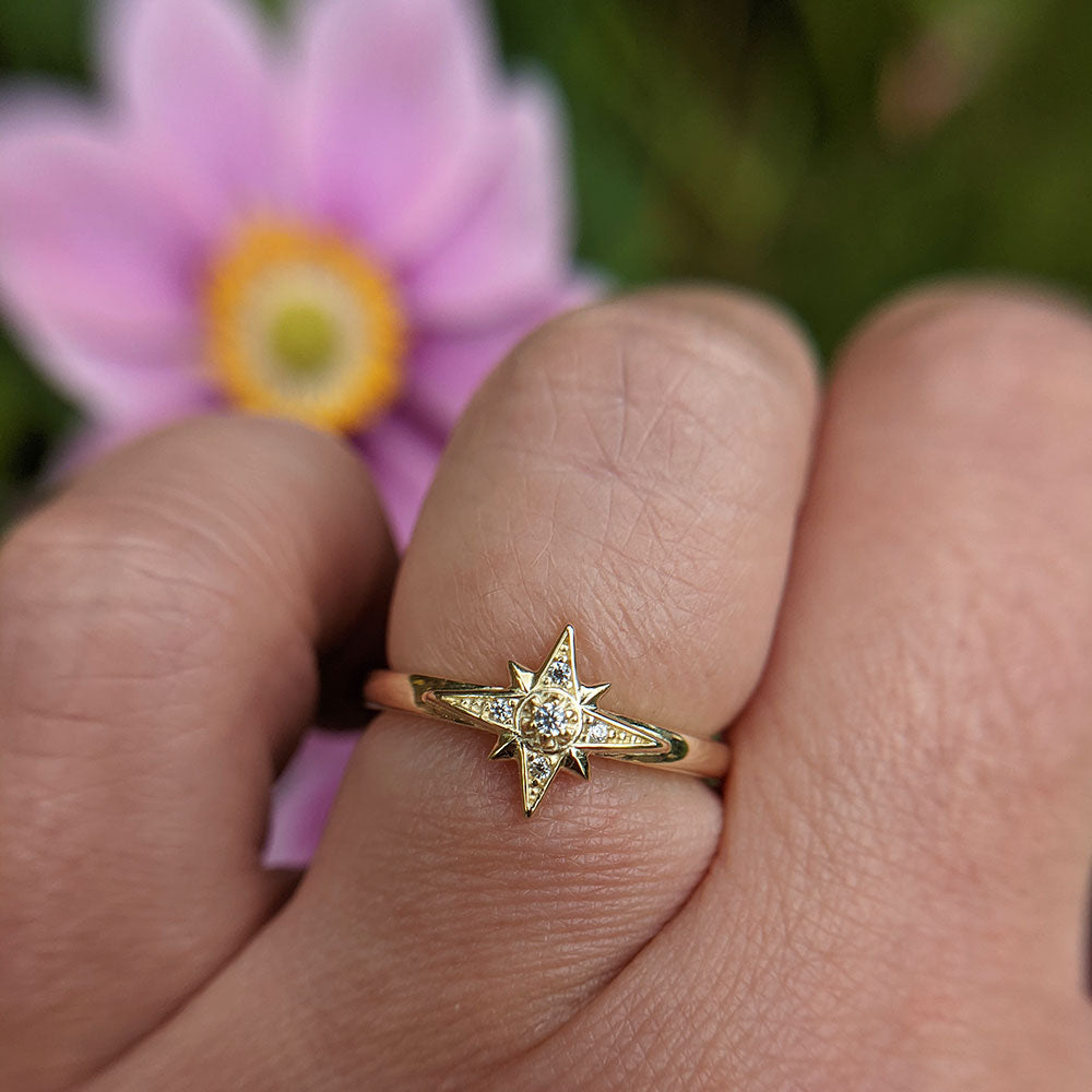 gold north star ring on hand