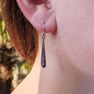 silver torpedo earrings in ear