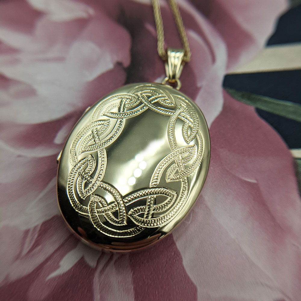 large oval gold locket with celtic knot engraving