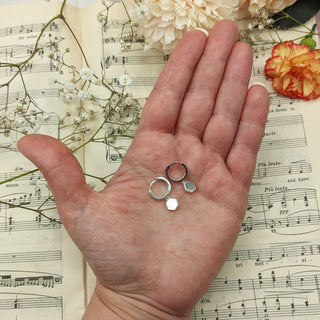 hexagon hoop earrings in hand for scale