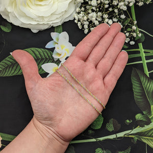gold rope chain necklace in hand for scale
