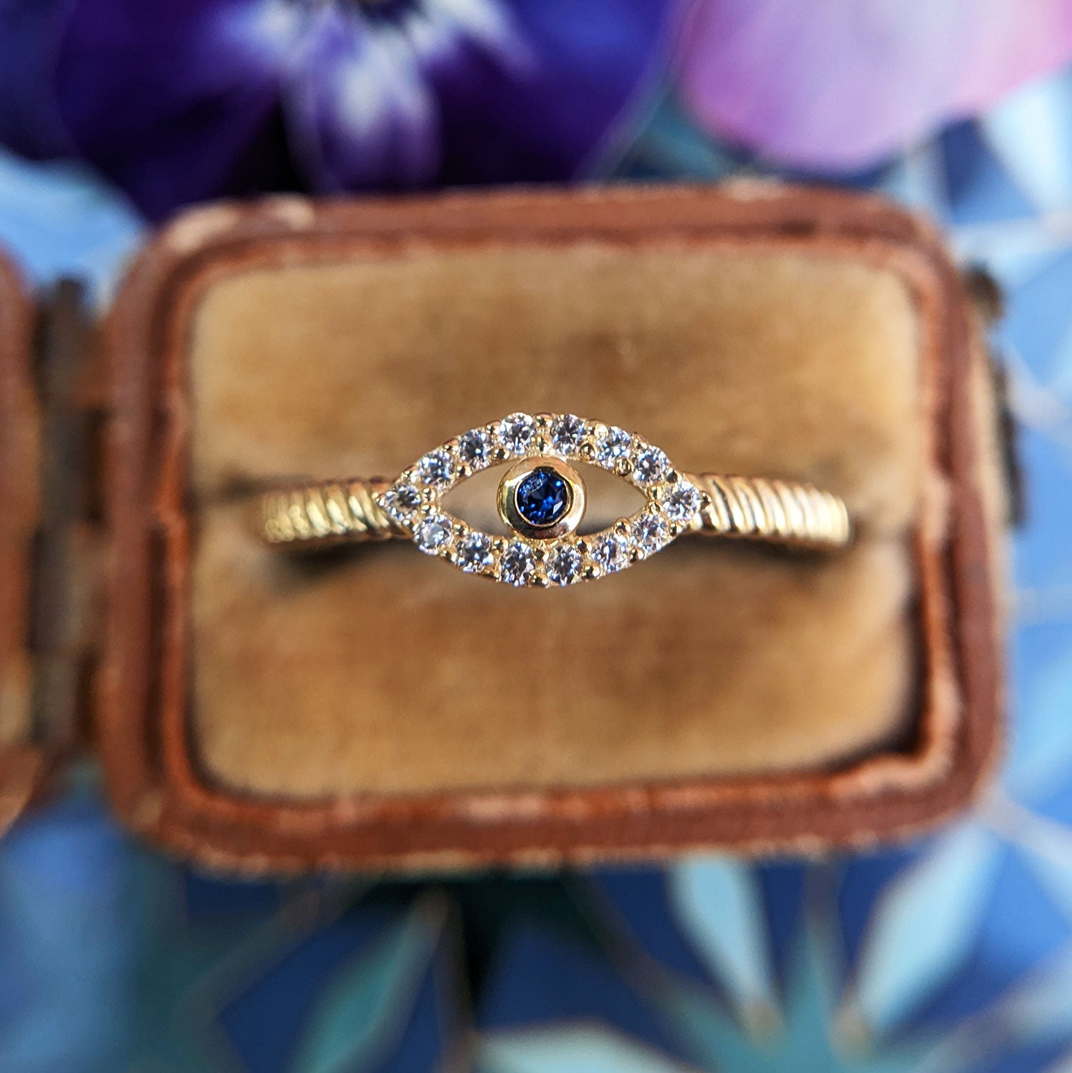 close up of yellow gold evil eye ring set with cz stones